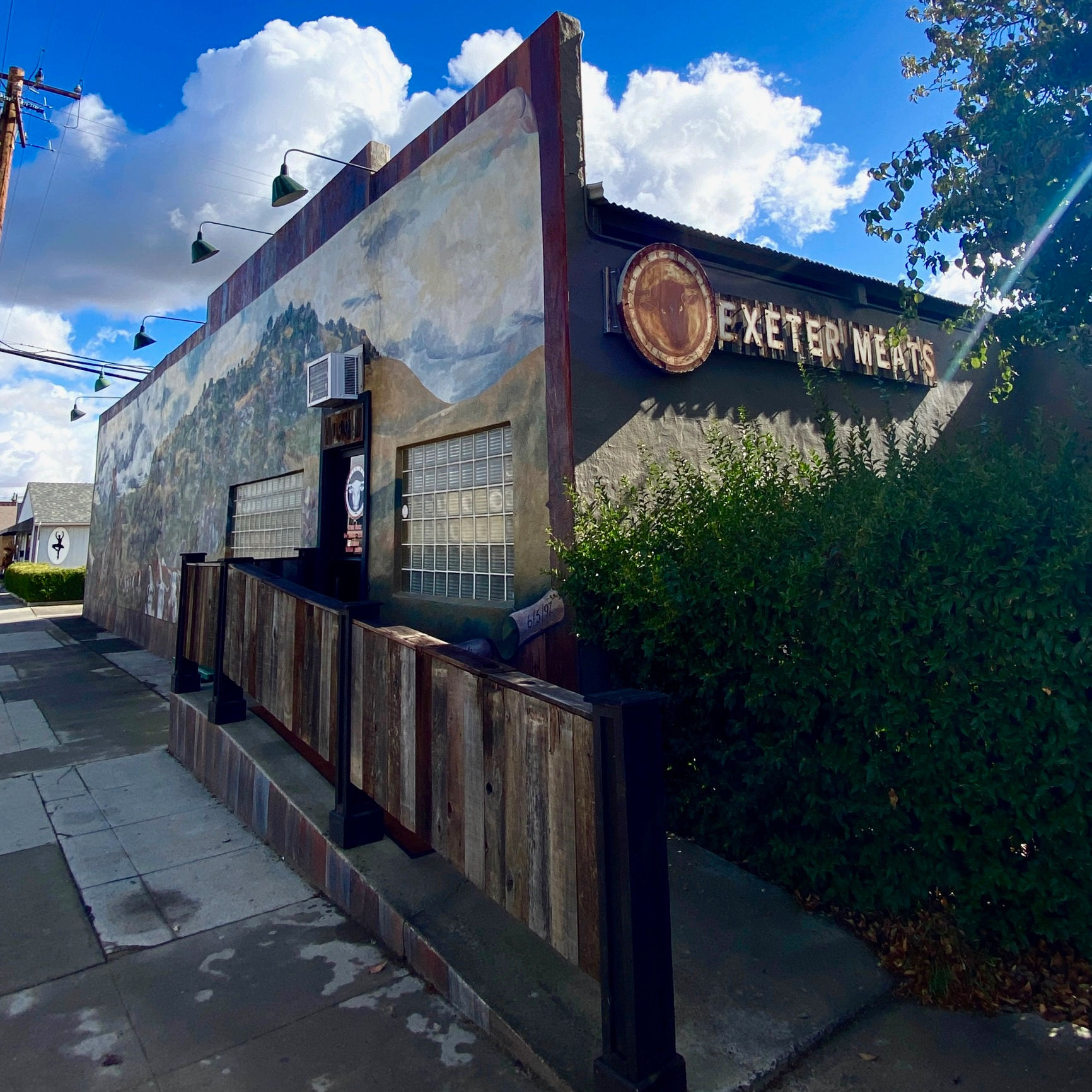 Exeter Meats on East Palm Street, with its carved longhorn sign and a painted mural running the length of the side wall.