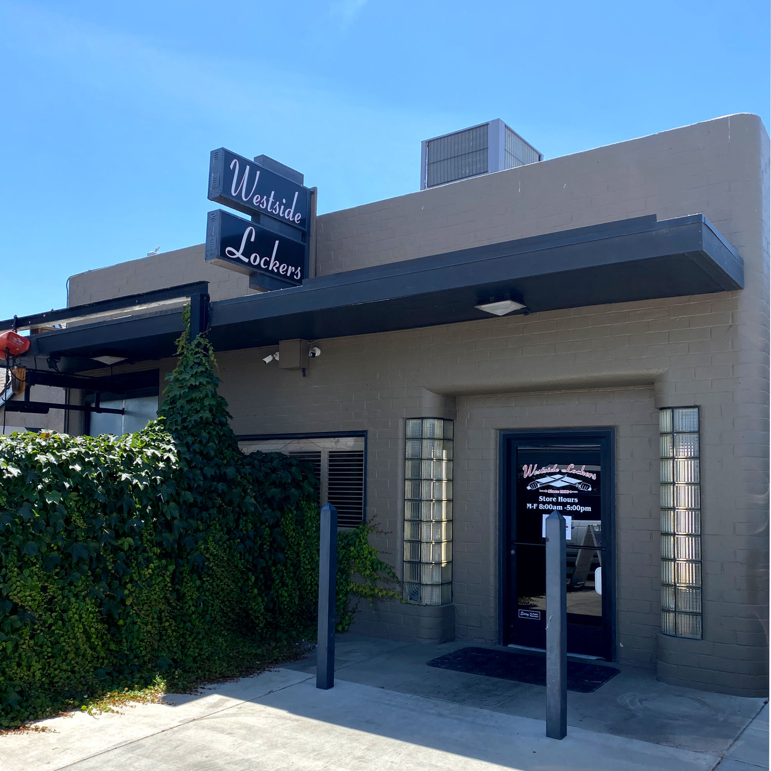 The Westside Lockers shop in Tulare — a mid-century block building with glass-brick windows and a black hanging sign.